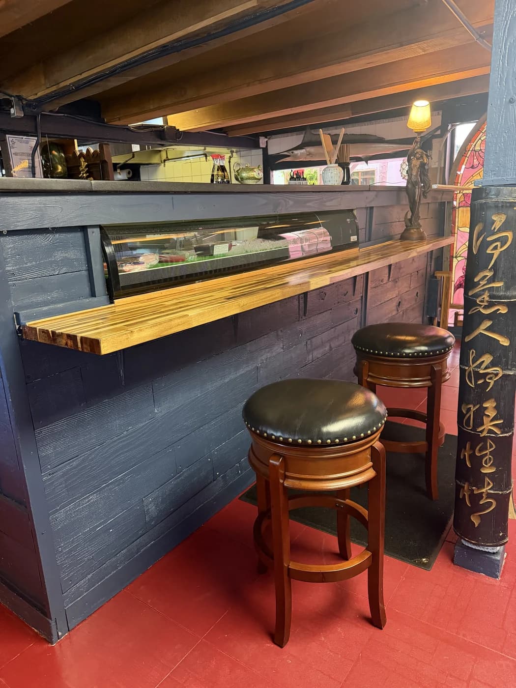 Two round leather stools at The Shack’s wooden sushi counter
