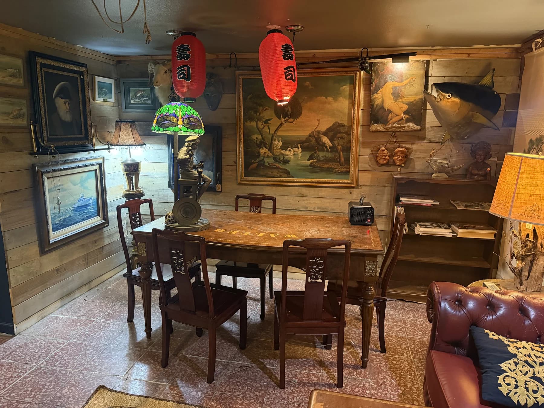 An intimate wooden dining table surrounded by lanterns, antique lamps and artwork at The Shack
